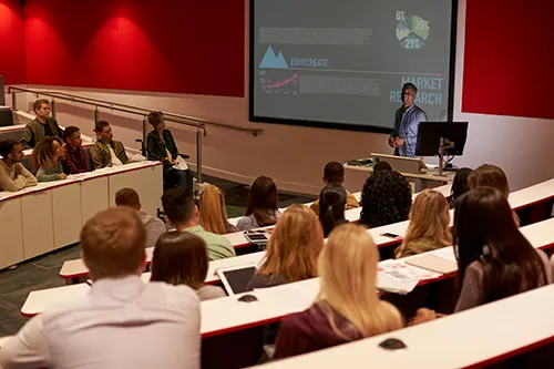 Students in large indoor clasroom with teacher