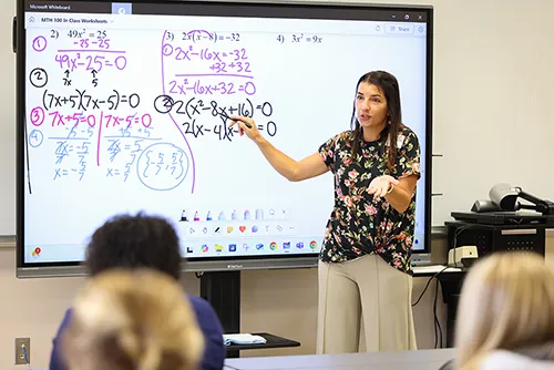 Math teacher pointing at screen