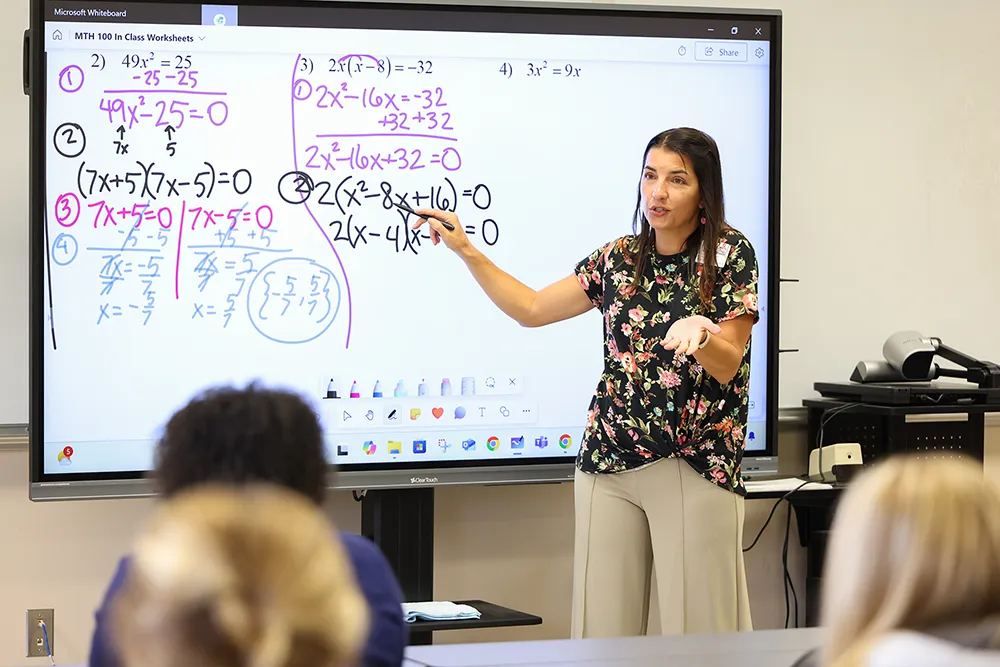 Teacher pointing at screen in classroom