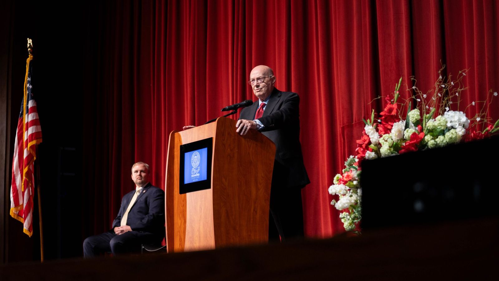 Chancellor Jimmy Baker delivers the State of the Community College System at Gadsden State Community College on Sept. 21. Brett Johnson, chief of staff for Gadsden Mayor Craig Ford, looks on.