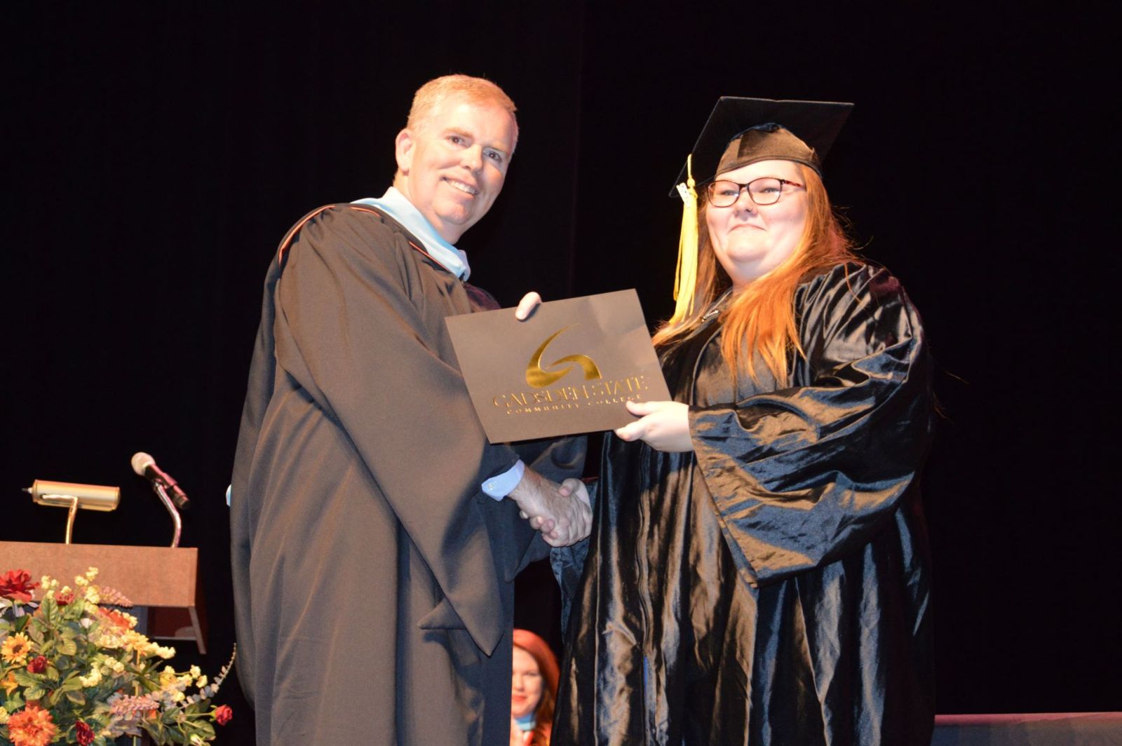 Alan Smith, dean of Workforce Development, awards a scholarship to Reannea Lanfair, a graduate of Gadsden State’s GED program