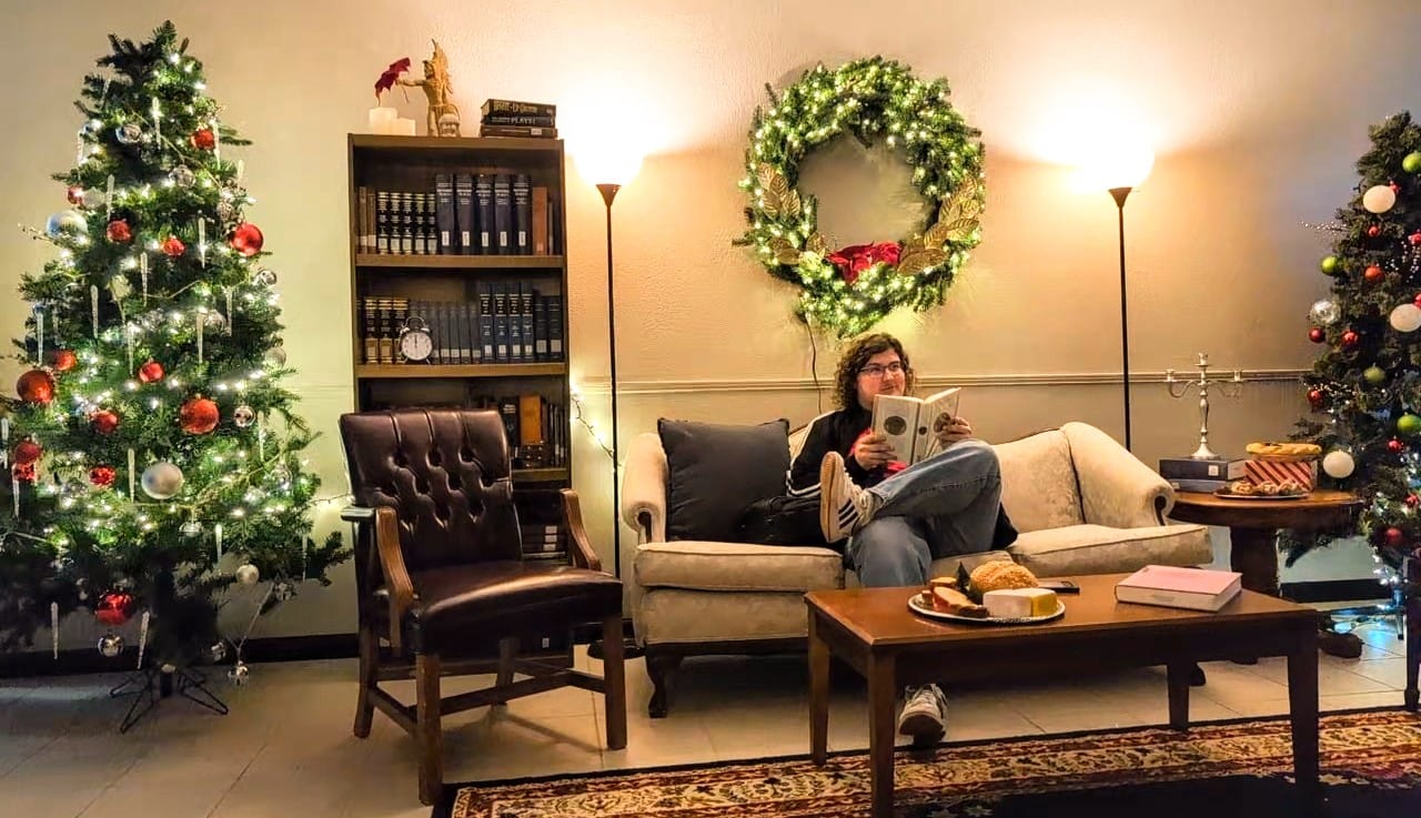 Ryan Kelly, Gadsden State Fine Arts student, sits back to enjoy the Christmas atmosphere after decorating for the performance.