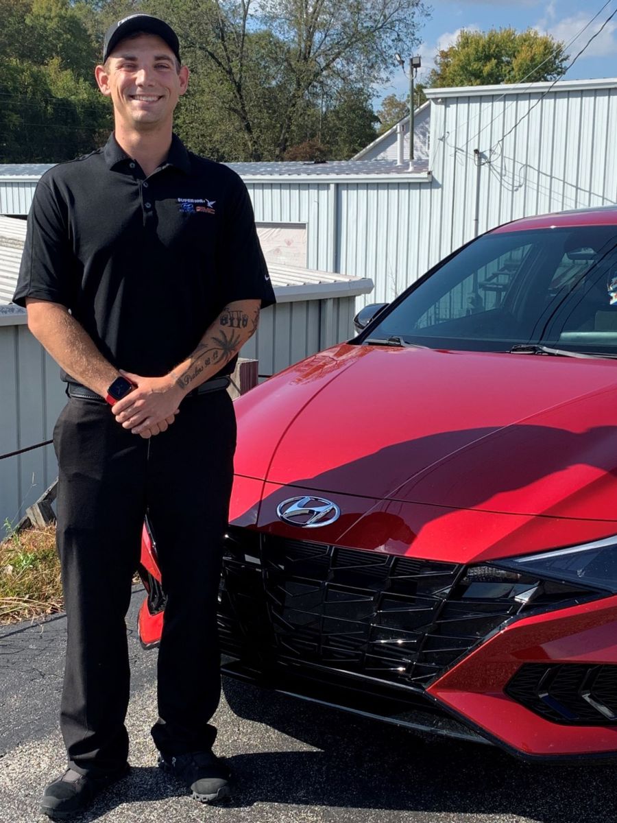 Sawyer Munsch is pictured with his new car at Superior Hyundai, where he has worked as a salesman since December